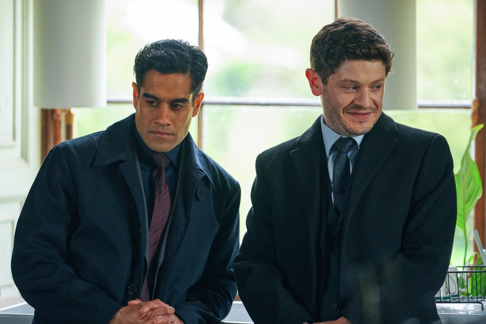 Molina (Iwan Rheon) and Honey (Sacha Dhawan) in Wolf, looking intrigued